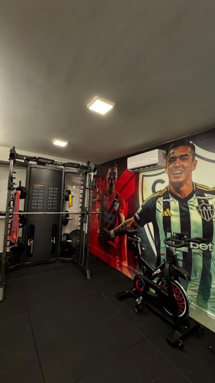 Sala de treino com rack, bike e mural de atletas do Atlético Mineiro